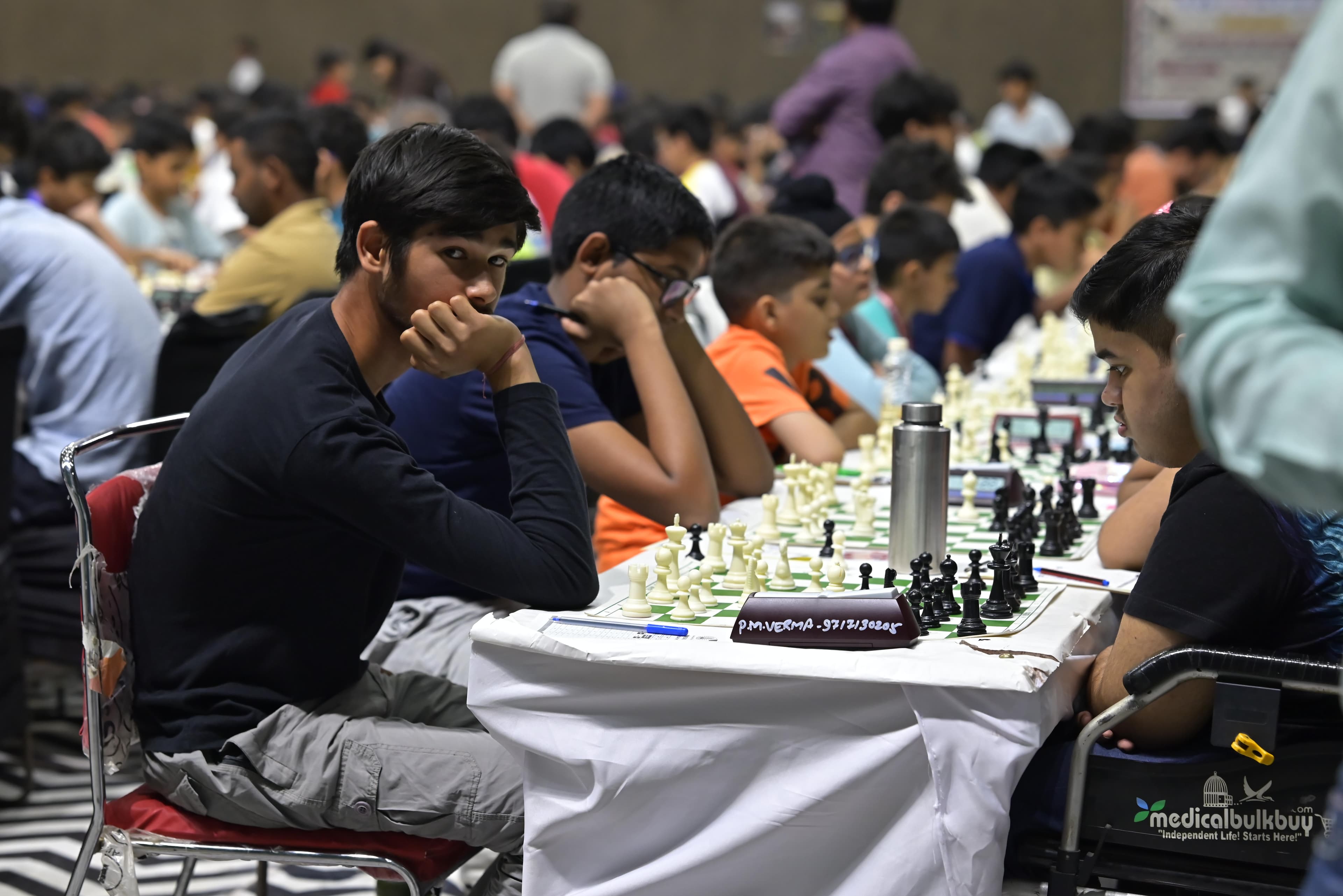 Chess players competing across a large event hall
